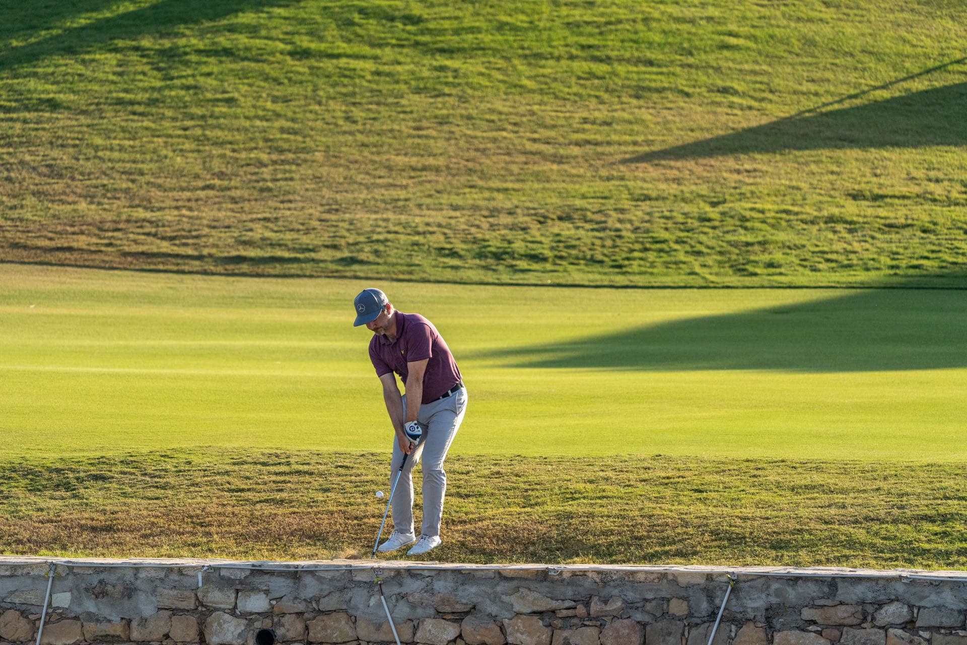 A European Tour player chips onto the green in golden-hour light at Aphrodite Hills, Cyprus, 2020, captured by Backlight Media