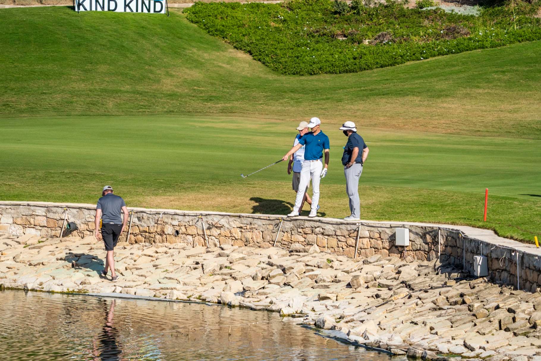 A player and masked caddie cross a stone causeway at Aphrodite Hills during the 2020 European Tour, inside the Covid bubble Backlight Media was cleared to work in