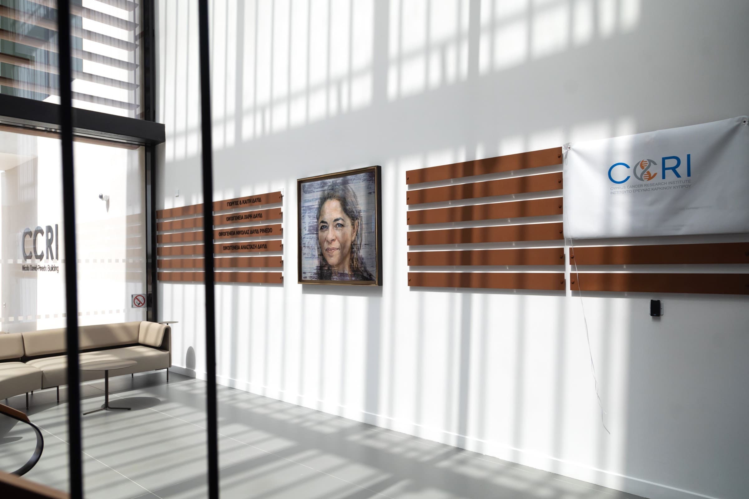 Light-filled lobby of the Cyprus Cancer Research Institute (CCRI) building at its grand opening, with CCRI signage and the dedication plaque, captured by Backlight Media