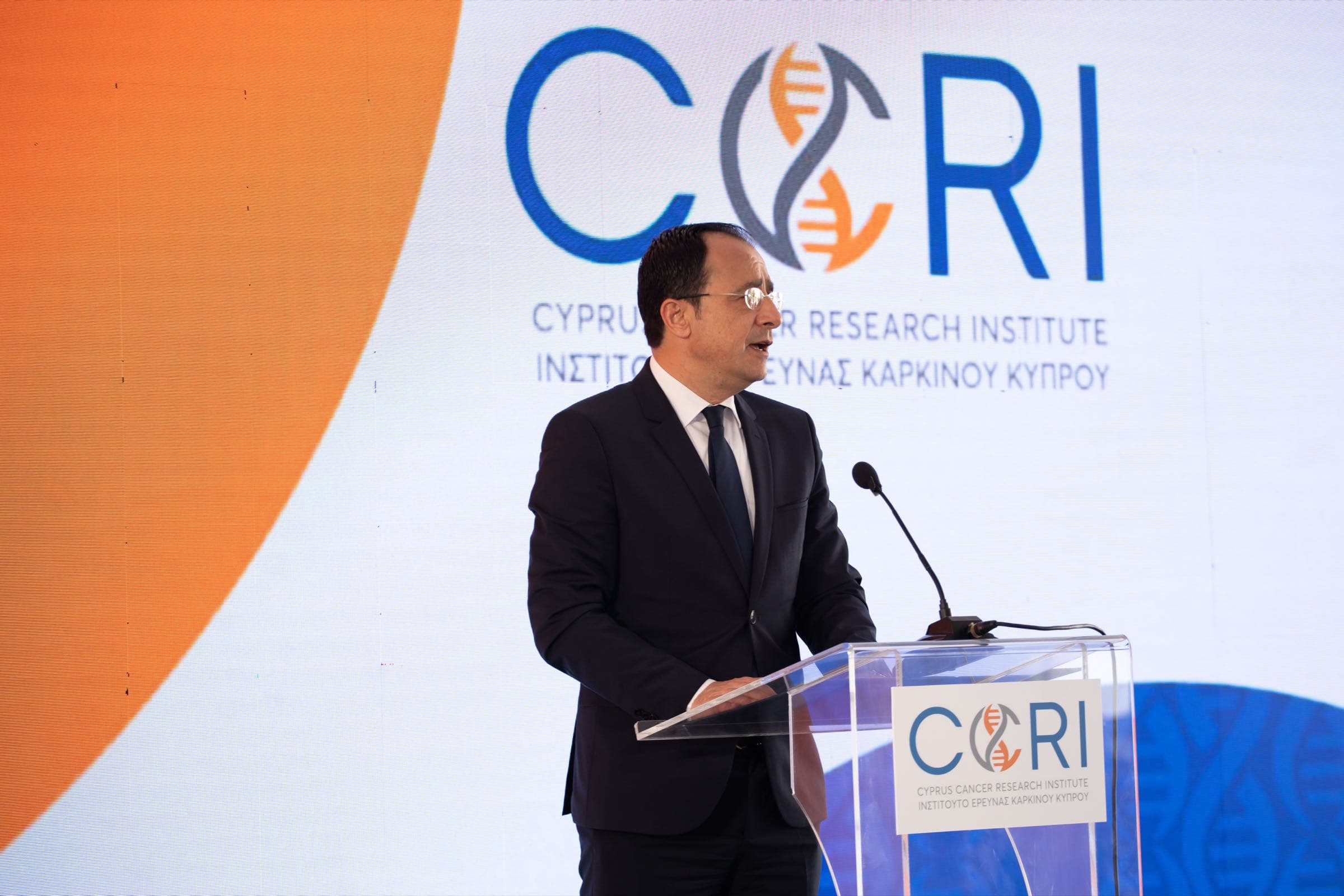 President of the Republic of Cyprus addressing the CCRI grand opening from the podium, the Cyprus Cancer Research Institute LED wall behind him, live opening produced end to end by Backlight Media