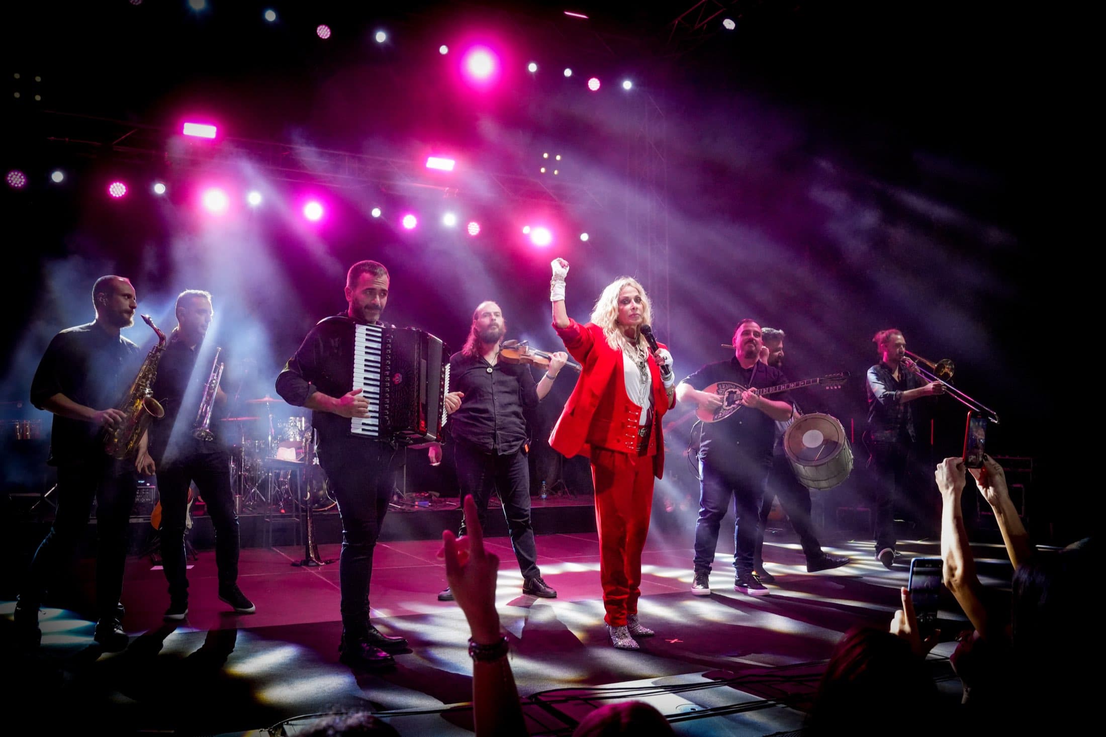 Full live band and lead vocalist on stage under magenta lighting at the Columbia Group flagship event, captured by Backlight Media