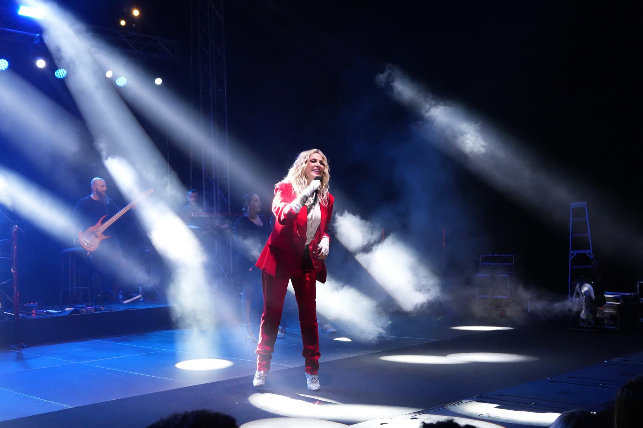 Solo vocalist under crossing spotlight beams and haze at the Columbia Group event, captured by Backlight Media