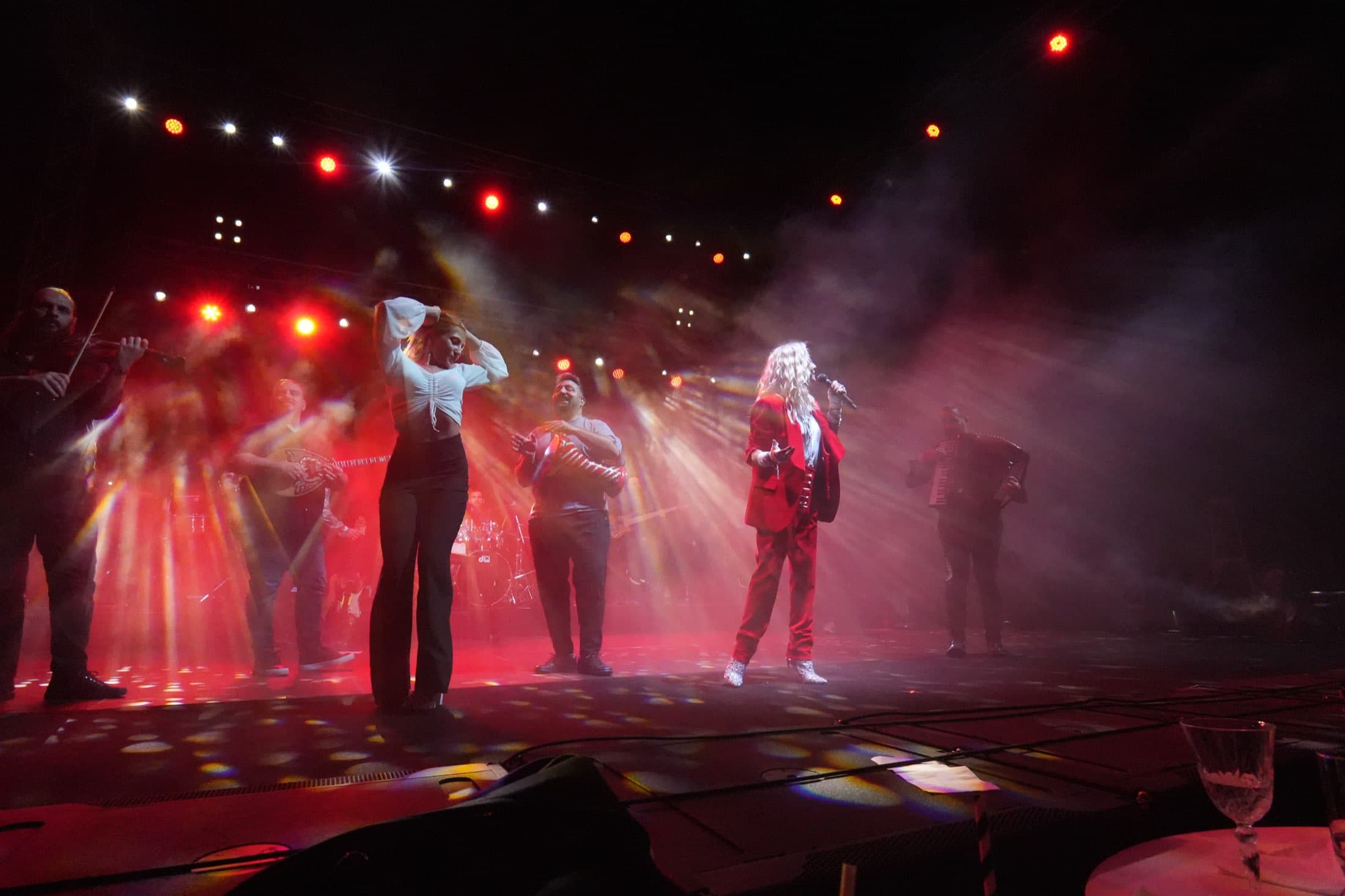 Full ensemble performing under red stage lighting at the Columbia Group flagship event, captured by Backlight Media