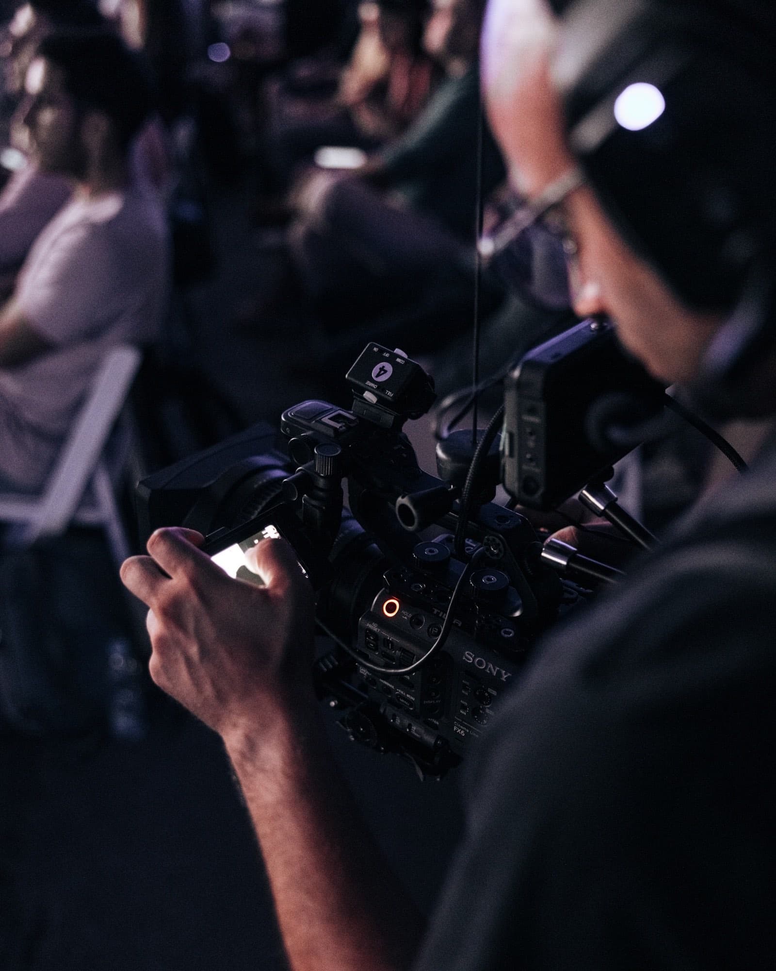 Close on a Backlight Media operator's hands on a broadcast cinema camera at Exness Week