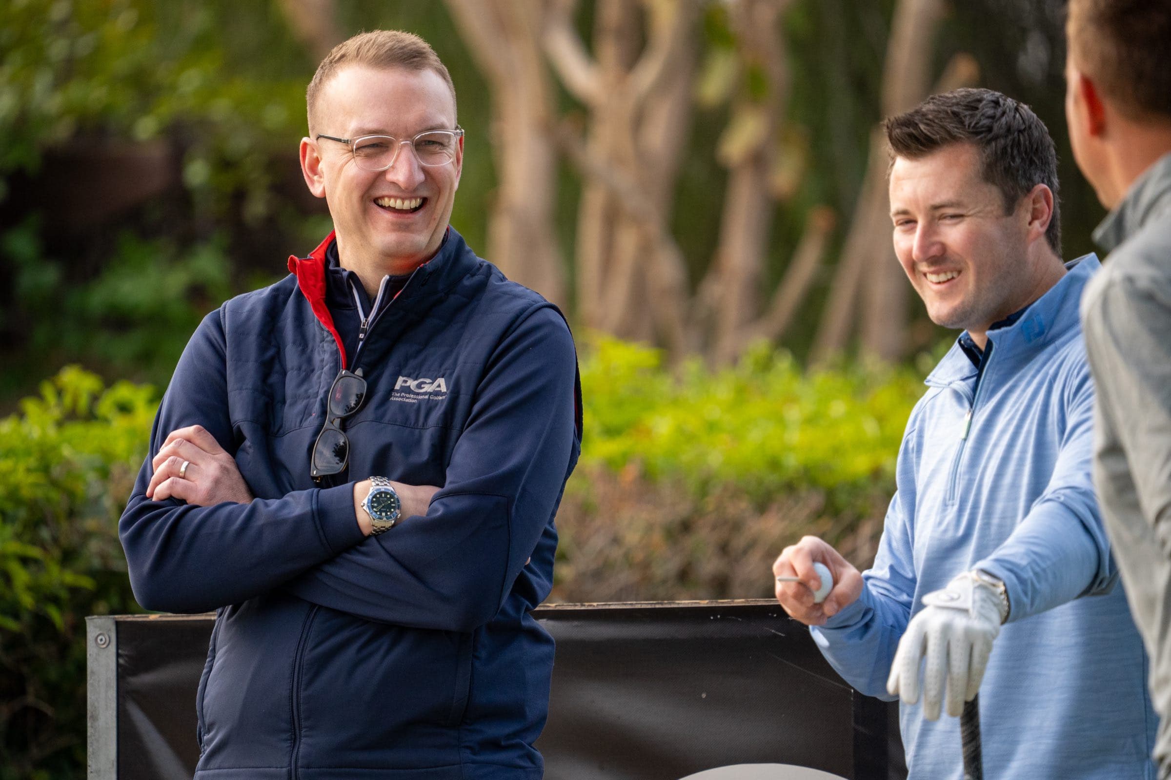 A PGA official and players sharing a moment beside the tee at the PGA National Cyprus play-offs, Aphrodite Hills, by Backlight Media