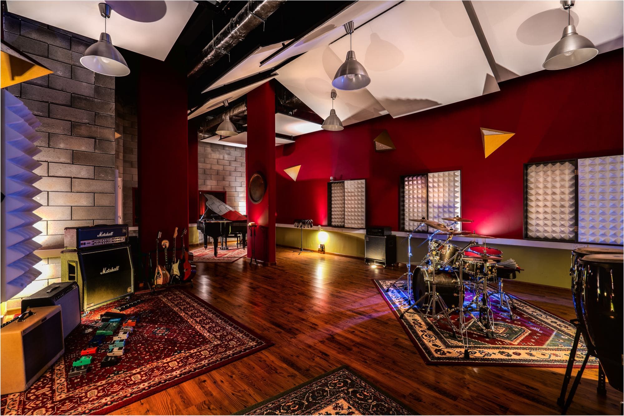 The live room at Soundscape Studios, with grand piano, drum kit and amplifiers, shot by Backlight Media