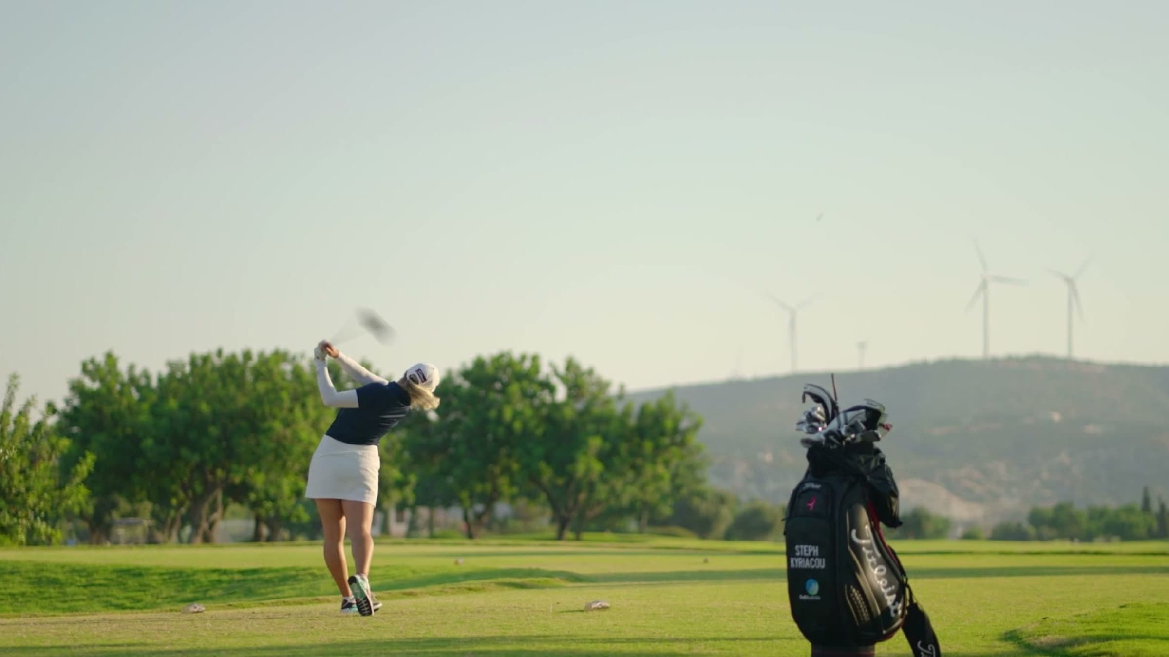 Steph Kyriacou mid-swing on the Aphrodite Hills course as brand ambassador, filmed by Backlight Media